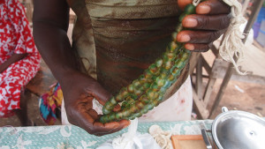 A woman demonstrates the process of bead cooking at Agomanya Market. The Advocacy Project/ Flickr.